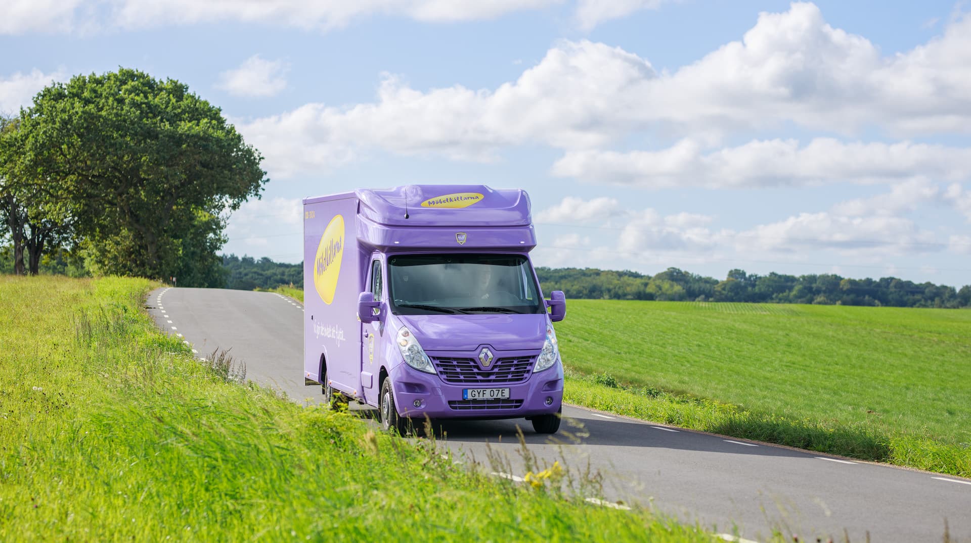 Möbelkillarna flyttbil ute och kör i öppet landskap